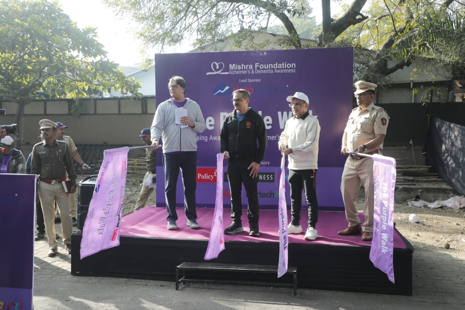 Participants walking together along a tree-lined road during The Purple Walk