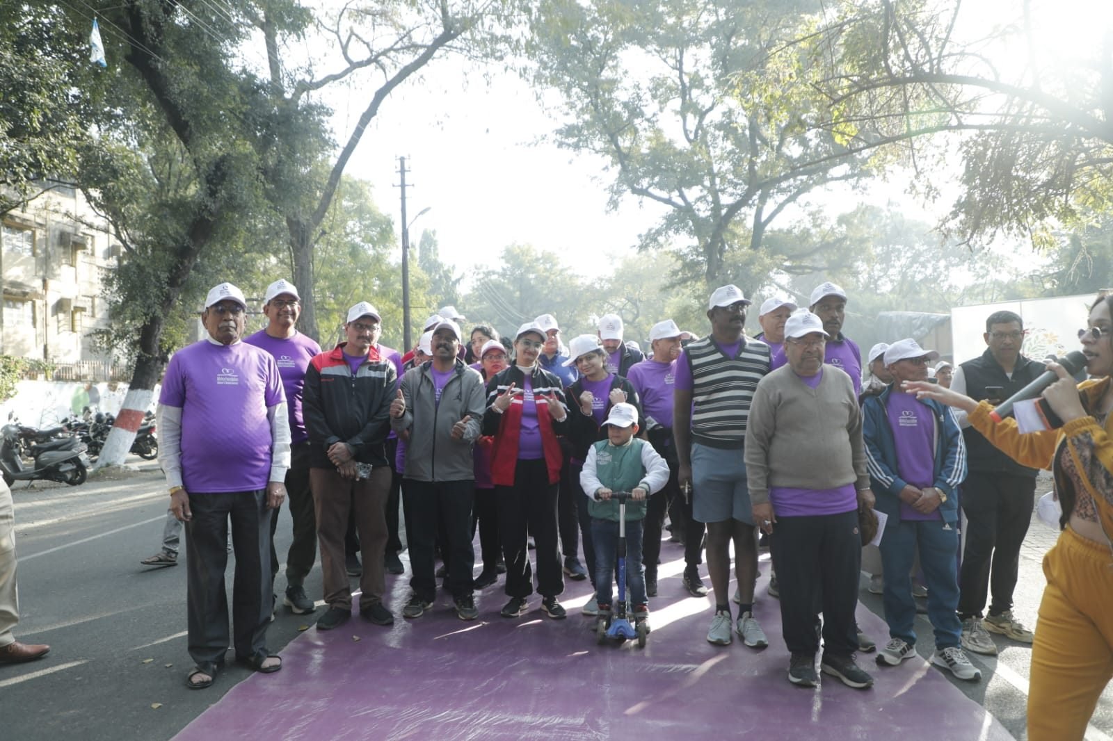 Elderly participants in wheelchairs holding awareness placards at The Purple Walk